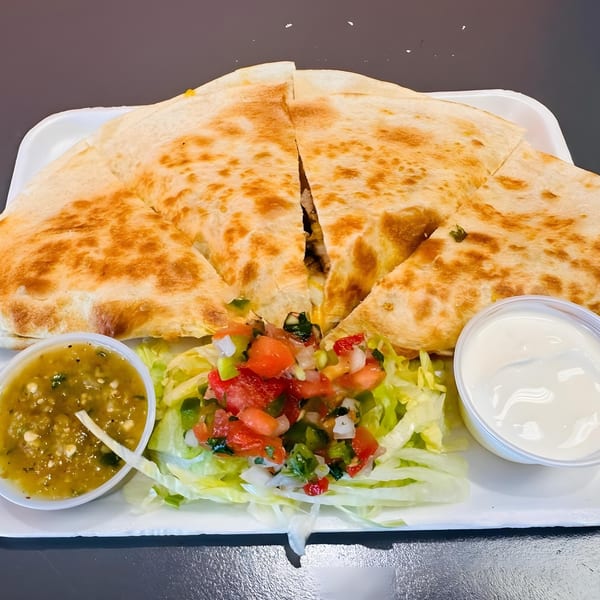 El Pollito Pio's quesadilla with salsa verde, pico de gallo, shredded lettuce, and sour cream.