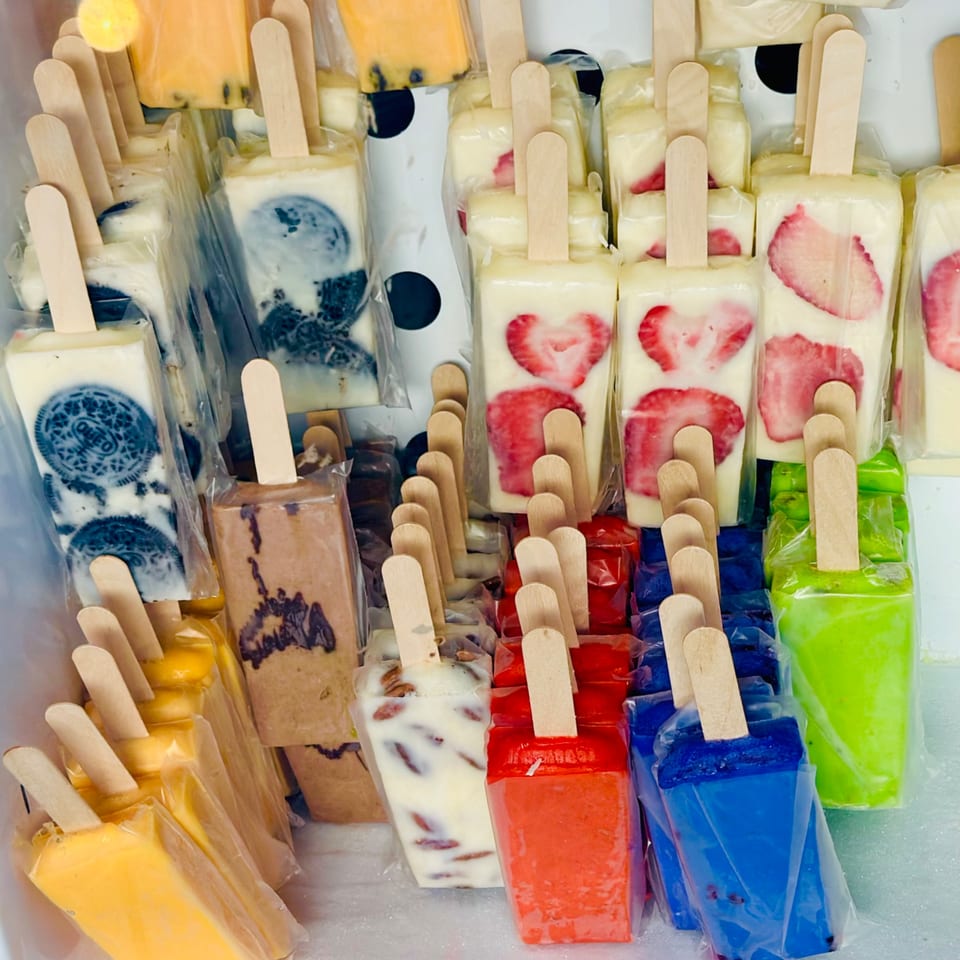 Assortment of colorful Mexican paletas, including strawberry, Oreo, mango, and other fruit flavors.