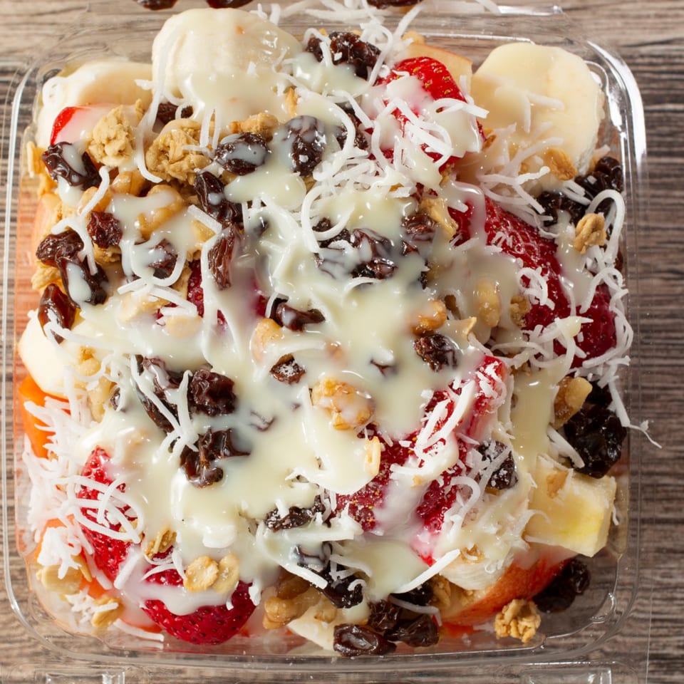El Pollito Pio's fruit cocktail with strawberries, bananas, granola, raisins, coconut, and cream.